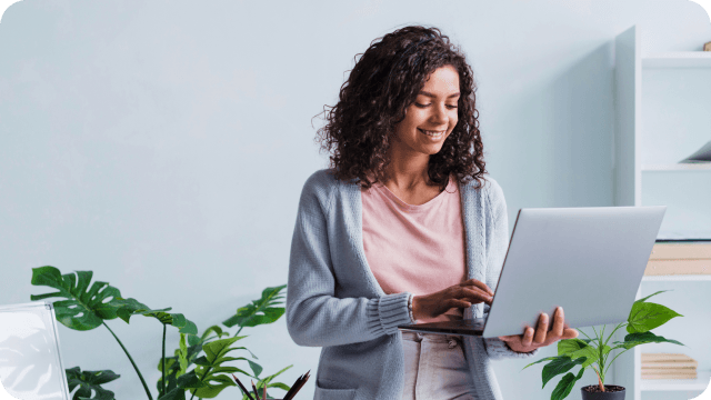 Jovem mulher sorri com o notebook nas mãos