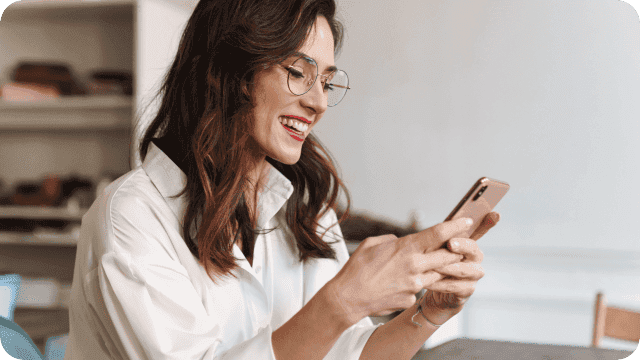 Mulher, participante do Indique IOB, lê o regulamento pelo celular