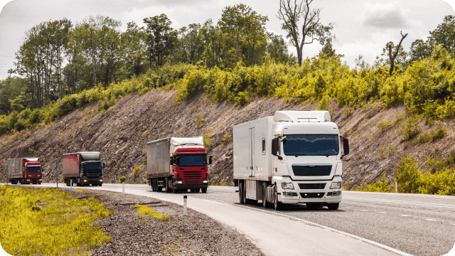 Uma fileira de caminhões rodando a estrada