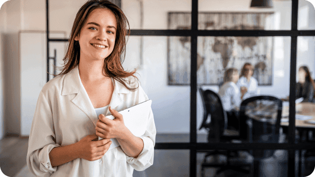 Contadora sorridente e sua equipe ao fundo