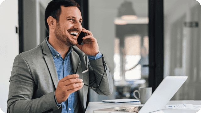 Empresário sorridente enquanto fala ao telefone
