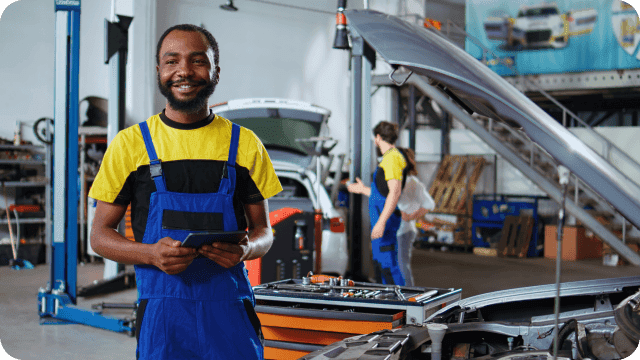 Mecânico em sua oficina com tablet nas mãos