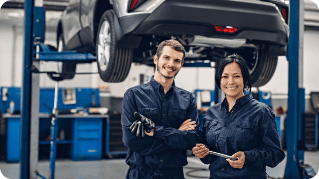 mecânico e mecânica sorridentes em sua oficina