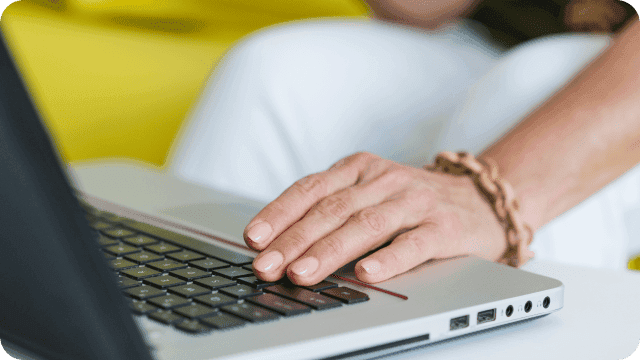 Mão de uma mulher digitando no notebook