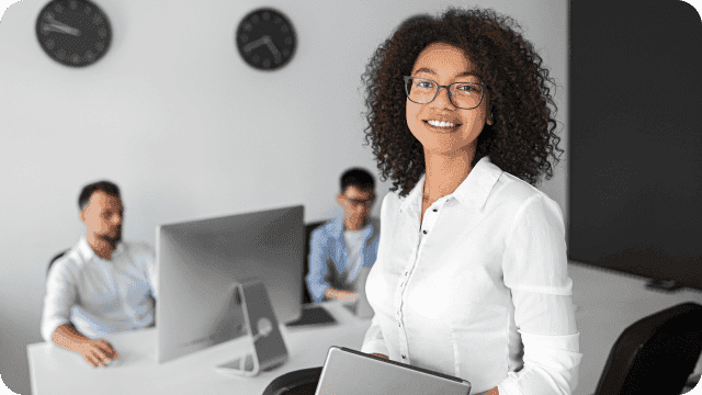 Profissional de RH sorrindo e equipe ao fundo