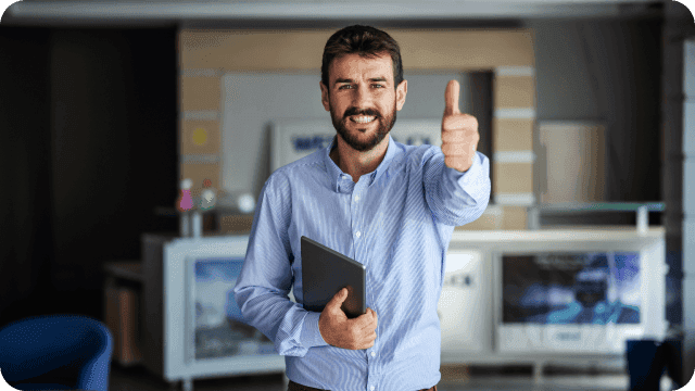 Vendedor sorridente faz sinal de "positivo" com a mão